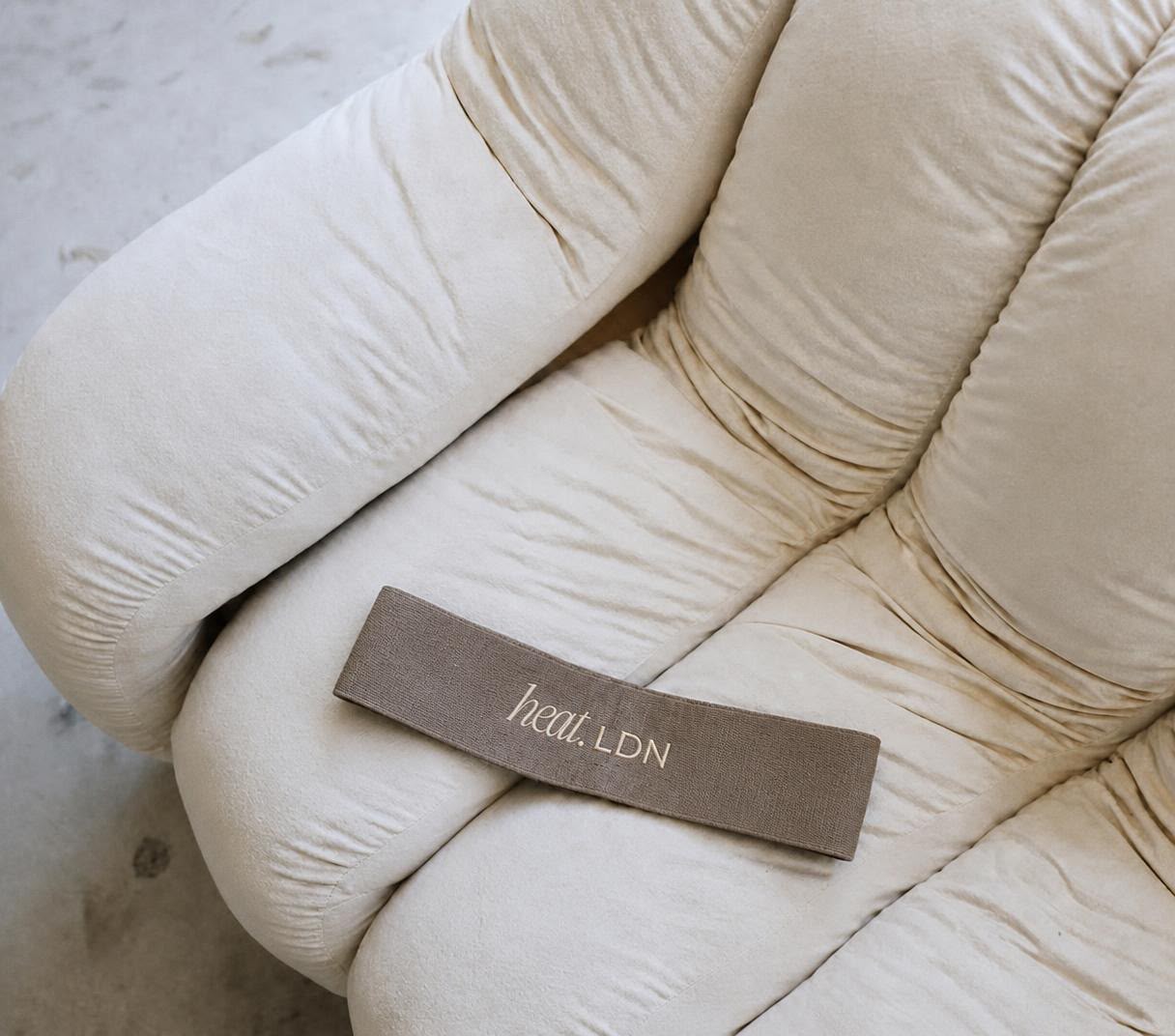 Taupe HEAT LDN booty band on a cream chair